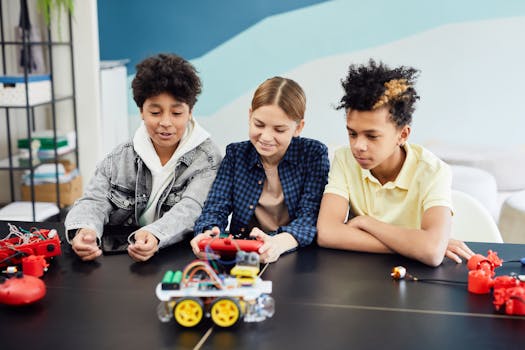 Group of Teenagers Sitting at the Table and Playing with Remotely Controlled Cars